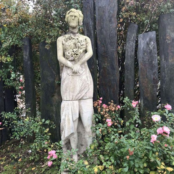 statue ancienne d'une femme avec des fleurs