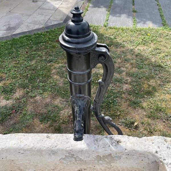 Pompe à eau ancienne en fonte noire