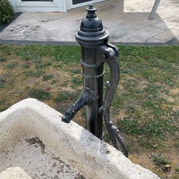 Pompe à eau ancienne en fonte noire pour jardin