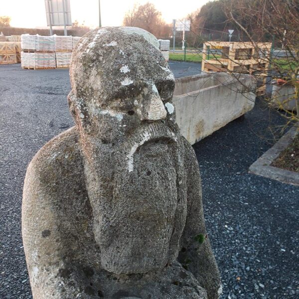 visage grave d'une statue d'homme en granit
